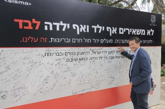 חתימה על קיר אמנת היוזמה באירוע ההשקה. צילום: עוז שכטר