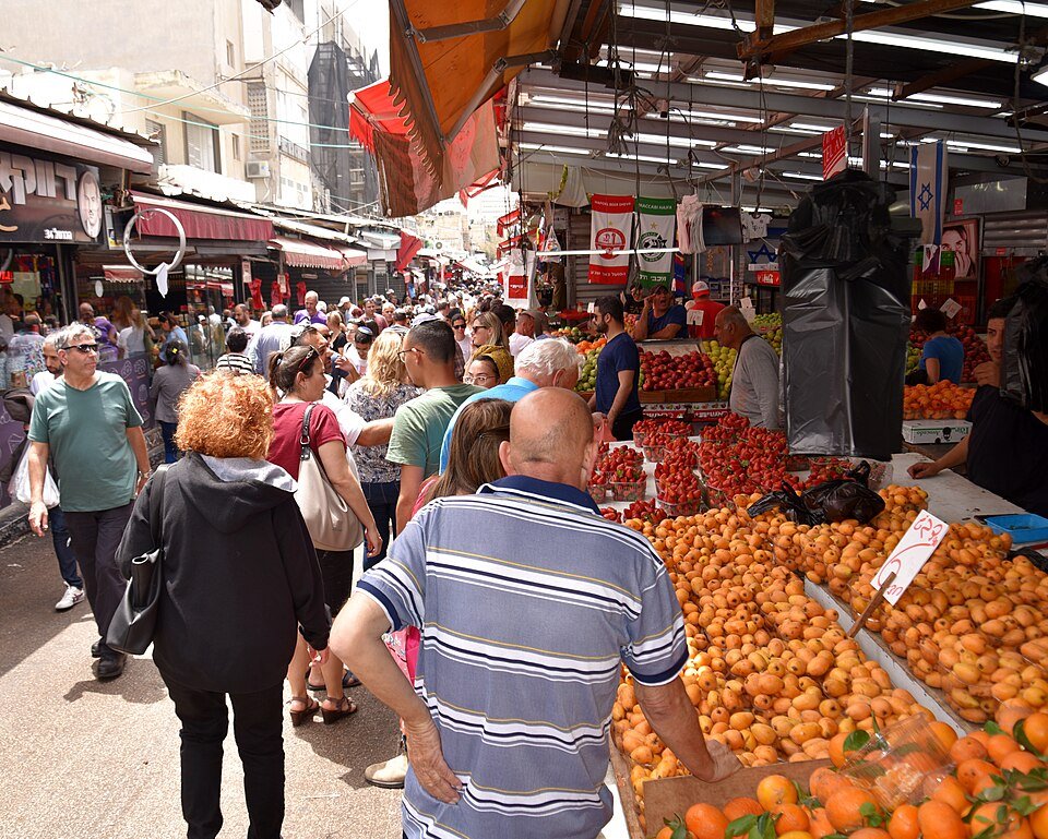 סמטת שוק הכרמל בתל אביב עמוסה בקונים ובדוכני ירקות