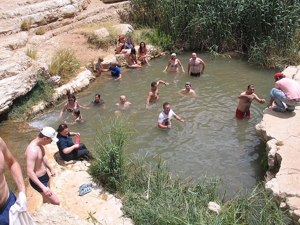 מטיילים נהנים מבריכת מים טבעית לאורך המסלול מעין פרת לעין מבוע