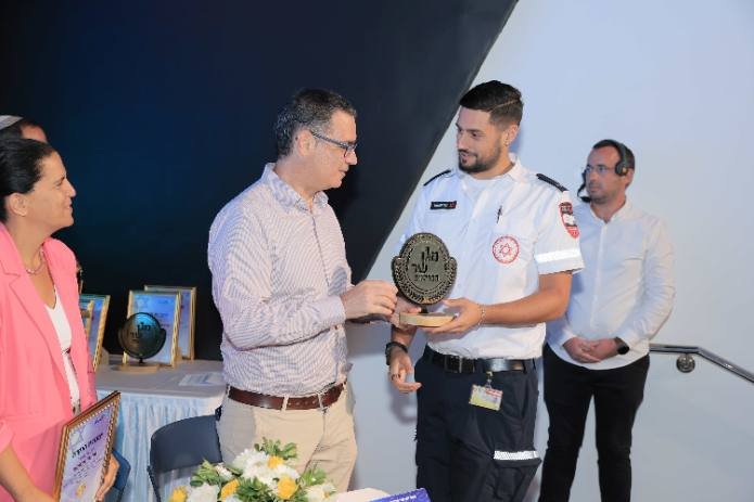 מתנדב מד"א מקבל את מגן שר הבריאות בטקס. צילום: אלירן אסייג